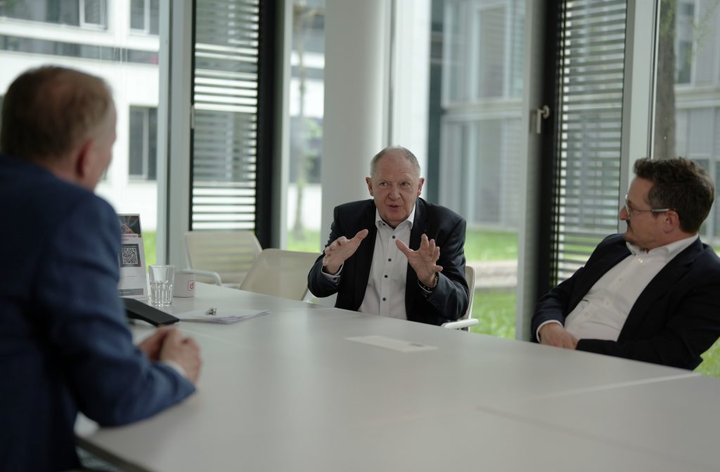 Ein Herr erklärt den anderen Personen seine Sichtweise